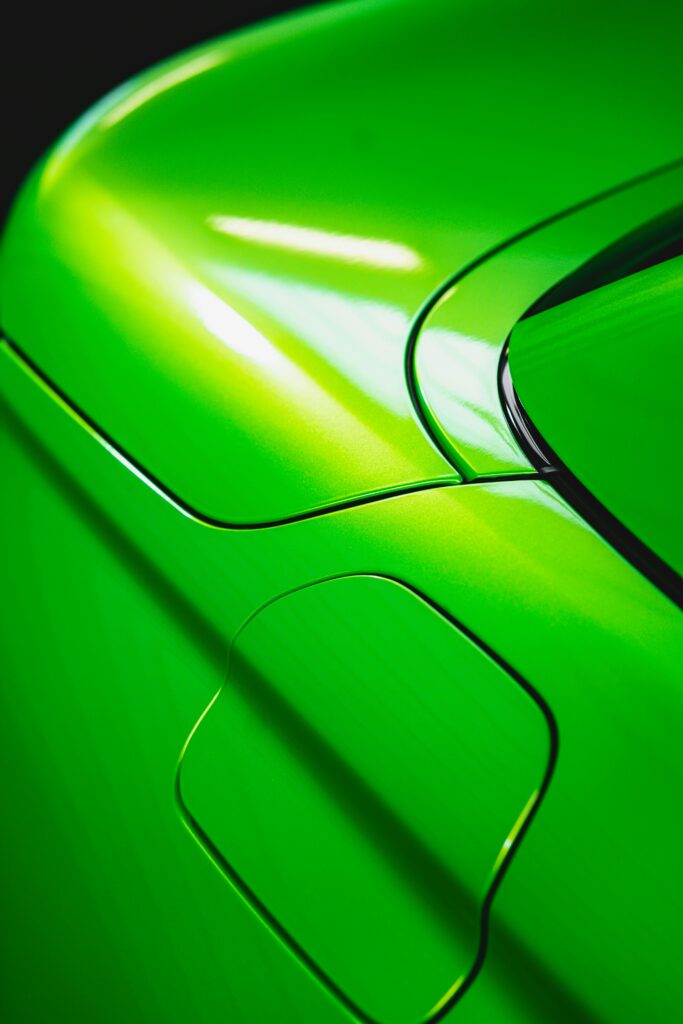 Shiny green luxury car with a focus on the gas tank door detail.